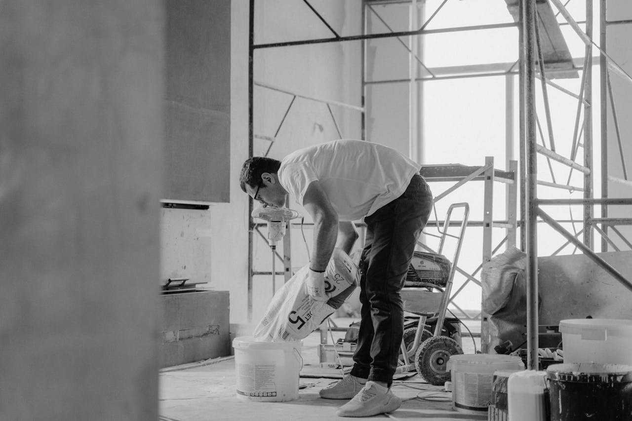 Man in White T-shirt and Black Pants Holding Plastic Bag